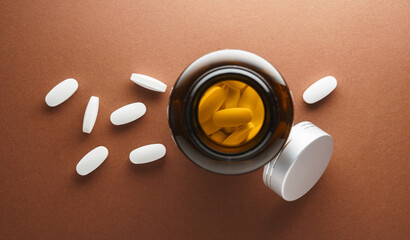 Białe tabletki rozsypane luzem z butelki z lekami - obrazy, fototapety, plakaty