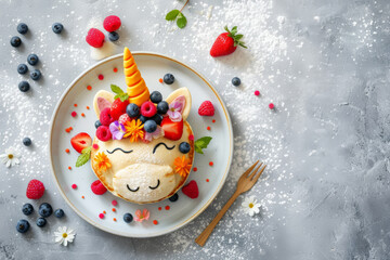 Top view of unicorn shape made from pancakes , decorated with berries and honey. On the simple plate.