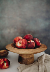 Peaches in wooden stand plate with dark background