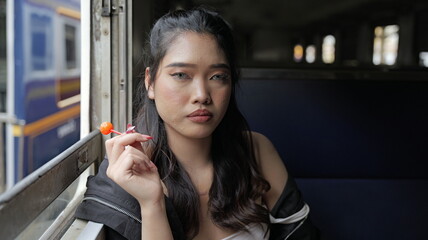 Young female train passenger with a lollipop in her hand