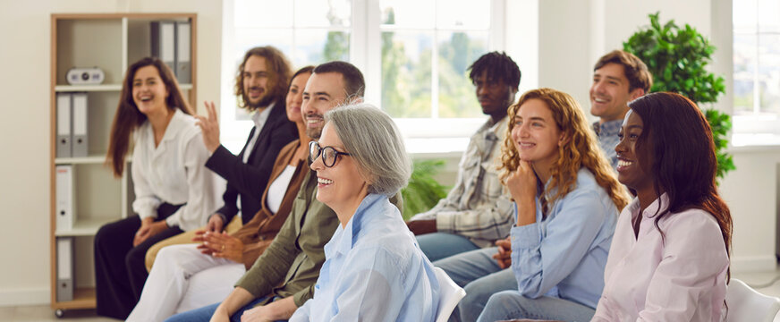 Candid happy diverse young senior female male businesspeople entrepreneur colleague audience at business forum event staff training listen to speech by successful coach making funny good humor jokes