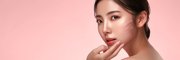 Young Asian woman with pulled-back hair, showcasing Korean makeup style and perfect skin on a pink background - obrazy, fototapety, plakaty