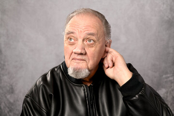 portrait vieil homme doigt dans oreille sur fond gris - 721171553