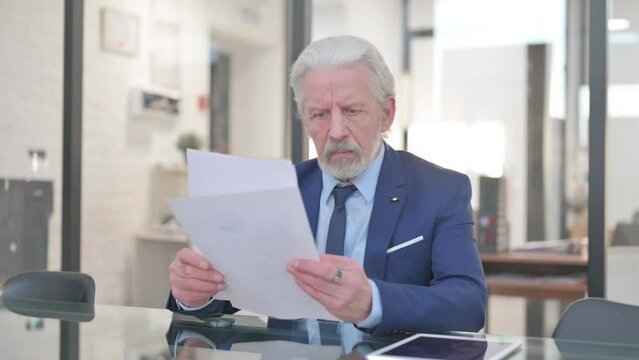 Old Businessman Reading Documents at Work