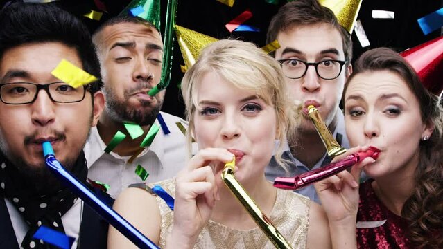 Birthday party, blower and group in celebration with happiness and confetti at event in slow motion. Happy, surprise and portrait of people with whistle, cheering and support of friends in community