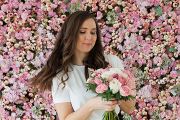 Gorgeous lady with flowers. Happy brunette woman indoor portrait