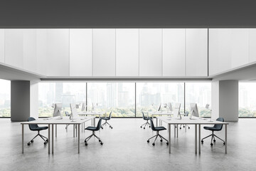Coworking interior with pc computers and armchairs in row, window