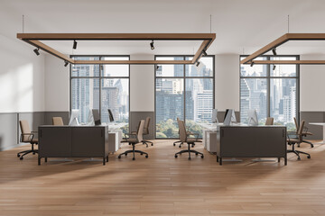 Stylish office coworking interior with pc desktop and armchairs in row, window