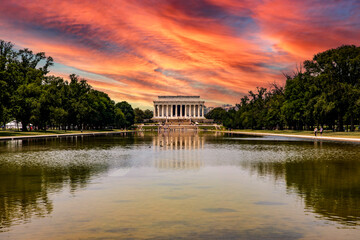 The Abraham Lincoln Memorial Temple reflected in the reflecting pool under an orange sky at sunset,...