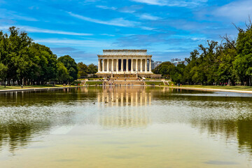 The Abraham Lincoln Memorial Pantheon reflected in the reflecting pool pond under a clear blue sky on the National Mall in Washington DC, USA. - obrazy, fototapety, plakaty