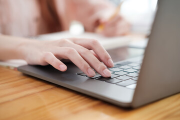 Hands Typing on a Modern Laptop Keyboard.
