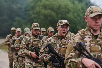 An elite military unit, led by a major, confidently parades through dense forest, showcasing precision, discipline, and readiness for high-risk operations