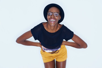 Fashion, laugh and portrait of black woman on a white background in trendy, stylish and casual clothes. Confidence, hipster style and isolated person with smile, glasses and happiness in studio