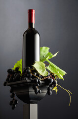 Red wine with blue grapes and vine branches.