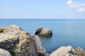 Fototapeta na wymiar Seascape. Waves wash over a large stone by the sea