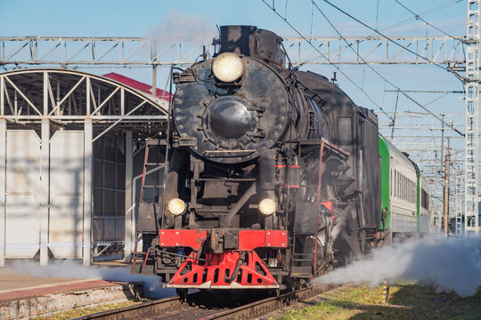 Retro steam train approaches to the platform. © serjiob74