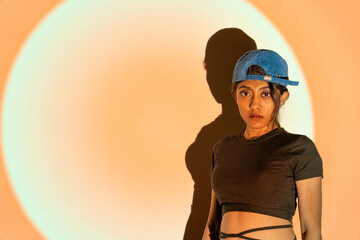 a multi-racial girl with a blue hat and a black T-shirt looking in the aggressive way with high attitude