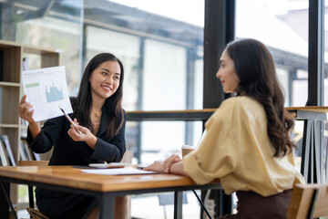 Two asian businesswoman accountants discuss financial management planning. Analysis of new startup project ideas