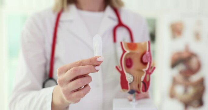 Soft suppository with laxative or for treatment of proctological diseases in hands of doctor. Proctologist and treatment of constipation in patients