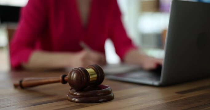 Person works on laptop and court gavel on table. Online auction or online crimes