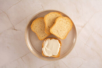 Toast with cream cheese in a marbled background in aerial view