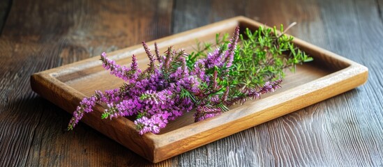 Heather or Calluna vulgaris flowers on a wooden tray for herbal tea