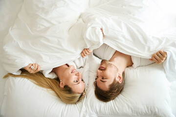 Young couple lying in bed in a hotel room