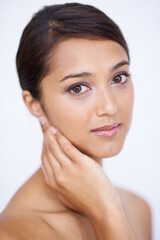 Obraz premium Portrait, cosmetics and woman with skincare, dermatology and grooming on a white studio background. Face, Indian person and model with shine and soft with healthy skin, smooth and aesthetic with glow