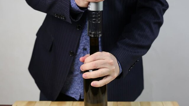 Opening a bottle wine with electric corkscrew. Electric device corkscrew for alcohol