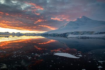 Antartica landscape with sea in the foreground and snow covered mountain in the background with...