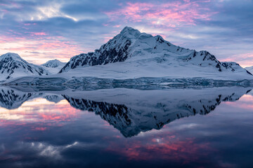 Fototapeta na wymiar Beautiful Antarctica landscape, huge mountain next to the sea with breathtaking reflection during midnight sun, sunset and sunrise in once, in Antarctica