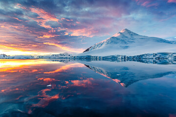 Beautiful Antarctica landscape, mountains next to the sea with breathtaking reflection during midnight sun, sunset and sunrise in once, in Antarctica - obrazy, fototapety, plakaty