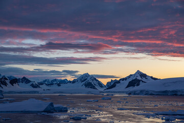 Beautiful Antarctica landscape, mountains next to the sea with breathtaking reflection during midnight sun, sunset and sunrise in once, in Antarctica