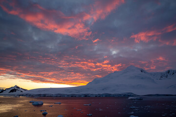Antartica landscape with iceberg with stunning sunset sky
