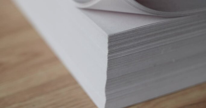 Hand flips through stack of white blank sheets of paper. Finding document in business documentation