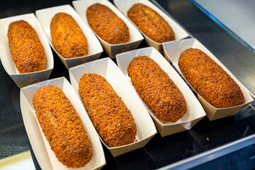 Kroket (croquette) in paper container, Dutch's favourite snack deep-fried ragout filled snack coated with breadcrumbs, A crunchy pastry of creamy ragout, Made of fresh bouillon and Dutch veal and beef