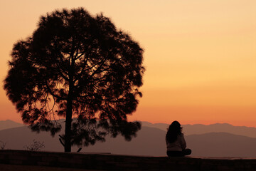 A lady meditating at the Kasar Devi Temple premises during sunset