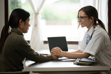 Fototapeta premium Female doctor sitting at work looking at the history of patients in the clinic or in the hospital