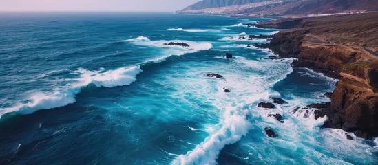 Poster Tenerife's volcanic coast experiences dramatic waves in aerial view. © 2rogan