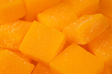 Dried and candied mango cubes background. Vegetarian food concept