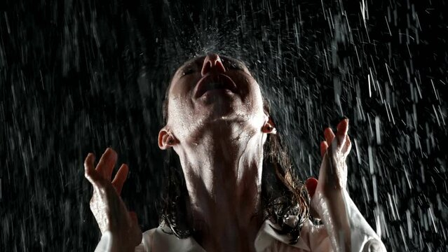 The emblem of the night, a woman bathed in rain in her white shirt, embodies passion and sensuality. Her portrait is a picture of a mixture of tenderness and audacity under the night sky