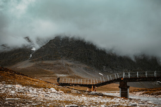 Mountain trail in Norway. Rainy weather in the mountains. Bridge on the trail in the Trollheimen mountains.