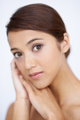 Fototapeta premium Portrait, cosmetics and woman with shine, beauty and grooming on a white studio background. Face, Indian person and model with dermatology and aesthetic with healthy skin, smooth and glow with makeup