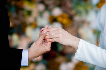 muslim groom in white dress wear wedding rings to left ring finger of muslim bride.concept for wedding card background, poster,Invitation card