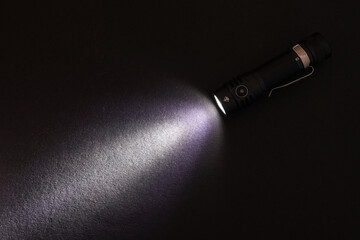 Flashlight and beam of light on a dark background