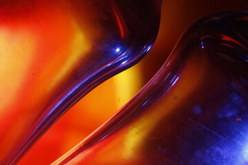 Curvas multicolor de una abrazadera de una jarra de cristal, por refracción del color, forma un...