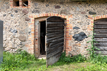 
Stone barn wall with open old wooden door in it