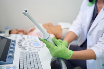 Ultrasound equipment using gynecologist doing examination to blurred woman