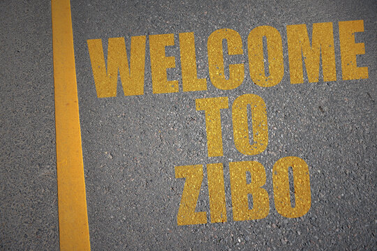 asphalt road with text welcome to zibo near yellow line.