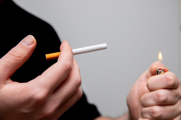 close up of a man starting to smoke a cigarette